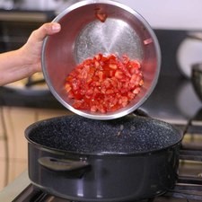Agregar en la misma olla dónde sellamos el pollo la cebolla picada, el jitomate picado.