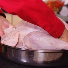Colocar el pavo con la pechuga hacia arriba en la pavera con la rejilla abajo.