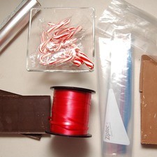 Ingredientes para receta 15 piezas de bastones de caramelo sabor menta 1 pieza de bolsa de plástico papel aluminio al gusto 300 gramos de chocolate con leche 300 gramos de chocolate semi amargo bolsa de celofán al gusto listón curly al gusto