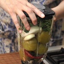 Moler los tomates y los chiles en la licuadora junto con el diente de ajo, el cilantro y un cuarto de cebolla.