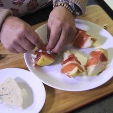 Envolver cada cuarto de pera con una tirita de serrano y espolvorear el queso azul encima de las peras envueltas y decorar con tomillo.