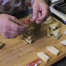 Pinchar la torre con el palillo y colocar encima un moño de jamón serrano.