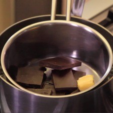 Derretir en la olla chica el chocolate y la mantequilla moviendo con una pala de madera hasta que se derrita uniformemente.