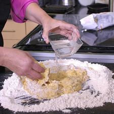 Mezclar los ingredientes del centro, agregándole poco a poco el agua, amasar hasta obtener una masa uniforme.