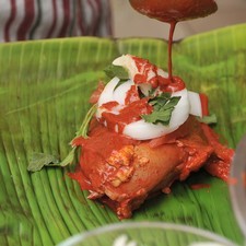Cortar el jitomate y la cebolla en rebanadas delgadas y poner sobre el pollo. Envolver cada pieza de pollo en una hoja de plátano con dos ramitas de epazote picado, rebanadas de jitomate y cebolla, una cucharita de manteca de puerco para darle sabor y sazonar con sal.