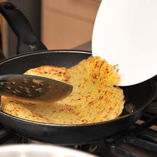 Voltear la sartén sobre un plato para sacar las papas. Colocar el sartén sobre la estufa nuevamente, agregar el resto del aceite y la mantequilla, esperar a que se caliente, Agregar las papas del lado que no se cocieron y cocer 5 ó 6 minutos más hasta que las papas estén doradas.