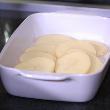 Cortar las papas en rodajas y colocar dentro de un refractario para horno las rodajas de papa.