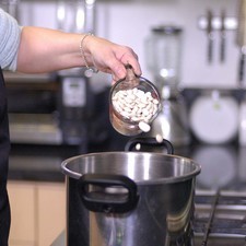 Colocar las alubias con agua y sal en una olla de presión. Tapar la olla y sellar bien en el número 2. Poner a fuego alto, cuando comience a silbar, bajar la lumbre al mínimo y cocer durante 25 minutos. Dejar enfriar por completo antes de abrir la olla. Reservar