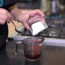 Para preparar el relleno de café, Añadir las dos cucharadas de azúcar al café y revolver bien para integrar. Rs 1485555899