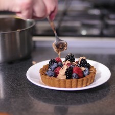 Para preparar el chocolate, colocar la olla grande sobre la estufa, agregar agua y poner dentro la olla chica flotando sobre el agua para lograr un efecto de “baño maría”. Encender la estufa, una vez caliente el agua, poner el fuego lo más bajo posible. Añadir el chocolate y continuar moviendo para que se derrita uniforme. Rellenar con la fruta y decora con hilos chocolate blanco. Rs 1486671215
