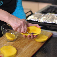 Sacar la pulpa de cada uno de los cachetes de mango con una cuchara.