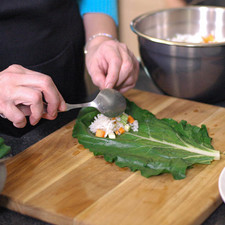 Colocar una hoja de acelga sobre la tabla para picar y rellenar con un poco de la mezcla de arroz.