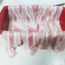 Preparamos la fuente poniendo la panceta ibérica cruzada cubriendo todo el fondo. Luego vamos a poner el relleno con los ingrediente antes hemos cocinado.