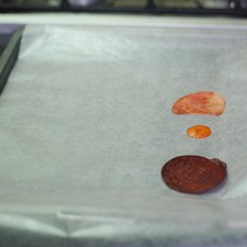 Colocar el papel encerado sobre la charola para horno y poner las rebanadas de betabel, zanahoria y papa sobre el papel, dejando un espacio entre cada rebanada. S 1494024216