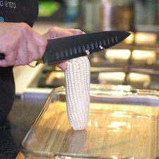 Desgranar los elotes con un cuchillo sobre la tabla para picar. Es mejor rebanar sólo dos filas a la vez y después repasar con el cuchillo para sacar toda la pulpa.