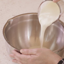 Añadir la crema para batir en un tazón y batir con la ayuda de la batidora hasta acremar un poco.