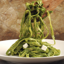 Servir la pasta montada en platos individuales, cubierta con la salsa pesto y decorada con cubitos de queso fresco.