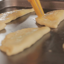Barnizar con la mezcla y colocar sobre una charola. Precalentar el horno durante 5 minutos. Hornear las empanadas durante 35 minutos o hasta que vean doradas.