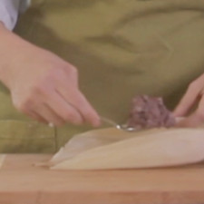 Colocar dos cucharadas de masa dentro de cada hoja y envolver.