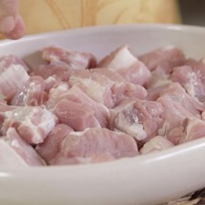 Picar finamente el cebollín. Salpimentar los trozos de costilla de cerdo por todos lados y reservar.