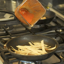 En el sartén donde se cocieron los ingredientes de la salsa, agregar un chorrito de aceite de oliva y cocer un poco las tortillas solamente a que se calienten y se ablanden. Agregar la salsa molida, revolver bien las tortillas. Agregar los camarones ya cocidos y dejar calentar un par de minutos.