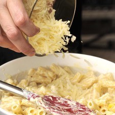 Agregar tres cuartas partes del queso rallado.