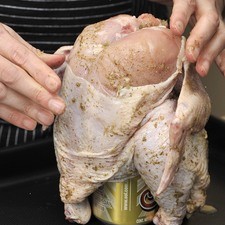 Montar el pollo parado sobre la lata de cerveza. Colocarlo sobre una charola para horno