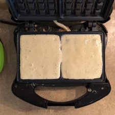 Coloca la masa en la wafflera cubriendo totalmente la superficie de los cuadritos. Cierra la máquina y espera de 3 a 5 minutos de acuerdo a la máquina, deben quedar de un tono café oscuro.