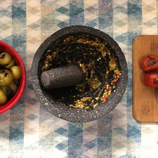 Prepara el molcajete, añade la sal y una cucharadita de sal, comenzamos a moler el ajo, los chiles de árbol y serranos.