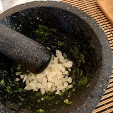 Añade el cilantro y la cebolla, trata de molcajetear lo más que se pueda la cebolla.