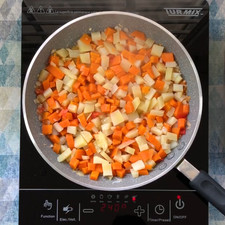 Coloca las papas con zanahorias, tapa el sartén durante 5 minutos a fuego medio.