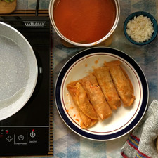 Una vez frita la tortilla cúbrela completamente en la salsa, puedes utilizar unas pinzas o con tus manos para que no se rompa, al final colócala en el plato, añade pollo y enrolla.