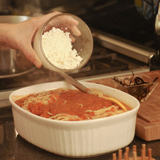Bañar el espagueti con la salsa de jitomate y la mitad del queso desmenuzado, revolver bien.