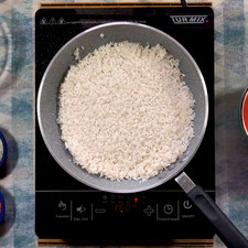 En un sartén coloca el aceite y deja calentando a fuego alto, agrega el arroz y fríe durante 3 a 5 minutos hasta que tenga un tono tostado y uniforme. Pasado este tiempo coloca media cebolla picada finamente.