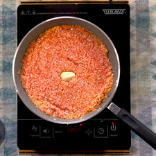 Agrega la salsa roja y mezcla muy bien, deja de 3 a 5 minutos a que el arroz absorba el jitomate hasta que se haga una pasta espesa, añade el diente de ajo.