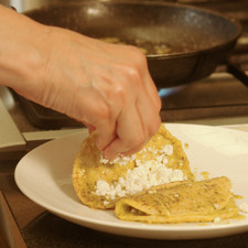 Colocar rebanadas de queso fresco al centro de la tortilla. Doblar las tortillas, acomodar en un plato y bañar con más salsa.