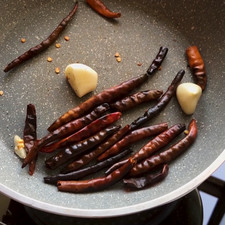 Asa o tatema los chiles durante poco tiempo a fuego alto, no dejes de moverlos ya que si se tuesta de más un chile éste puede amargar la salsa, recomiendo tres minutos. El ajo puedes dejarlo hasta que todas las partes estén asadas.