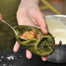 Rellenar un par de chiles con picadillo.