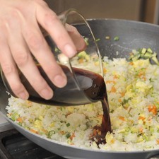 Mezclar el arroz con los huevos revueltos, agregar a la sartén de las verduras y calentar. Sazonar con la salsa de soya, el jengibre, la pimienta