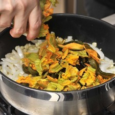 Agregar las rajas de chile y las flores de calabaza continuar cociendo hasta que se consuma el agua que sueltan, aproximadamente 5 minutos.