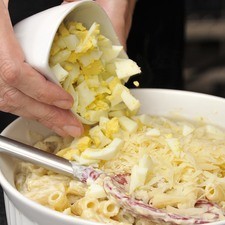 Poner los huevos duros picados y el perejil, espolvorer con queso rallado restante.