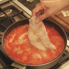 Cuando la salsa se torne rojo intenso, agregar las aceitunas (con o sin hueso o rellenas de pimiento morrón rojo), los chiles güeros en rajas y los filetes de pescado. Cuando suelte el primer hervor, bajar la lumbre y cocer tapado de 10 a 15 minutos.