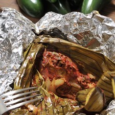 Abrir los bultitos y servir cada pieza de pollo acompañada de jitomate, cebolla y chile picados.
