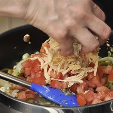 Picar el jitomate en cubos pequeños y el ajo finamente y agregar al sartén de las rajas. Añadir el pollo desmenuzado, sal al gusto y dejar sazonar por 10 minutos.