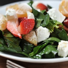 Colocar las espinacas en platos individuales. Colocar sobre ellas las fresas, gajos de mandarina, nueces y el queso de cabra cortado en rodajas. Servir en platos individuales.