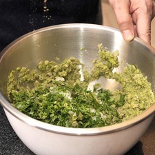Picar el resto de la cebolla muy finamente. Lavar y picar el perejil. Agregar la cebolla, los nopales picados y el perejil.