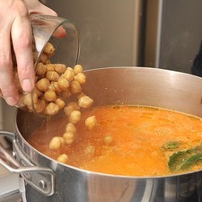 Añadir los garbanzos cocidos y escurridos junto con los chipotles enteros y el pollo desmenuzado, sazonar con sal al gusto y continuar cociendo 5 minutos para que se integren los sabores.