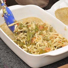 Colocar una capa de tortillas en un refractario. Continuar con otra del guisado. Añadir una capa de crema y otra de queso. Repetir hasta cubrir el refractario a toda su profundidad. Cubrir con papel aluminio. Hornear a 350°F (180 °C) aproximadamente 20 minutos o hasta que el queso esté derretido. Destapar y continuar horneando 5 a 10 minutos para que el queso quede dorado.