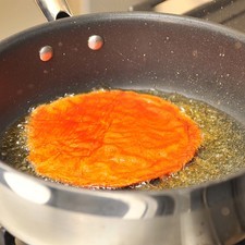 Pasar cada tortilla por un poco de salsa de chile colorado, freír en una sartén con aceite a fuego medio unos segundos por un lado y otros por el otro.