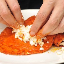 Sacar y colocar en un plato, rellenar con queso fresco desmenuzado, enrollar y espolvorear con más queso.
